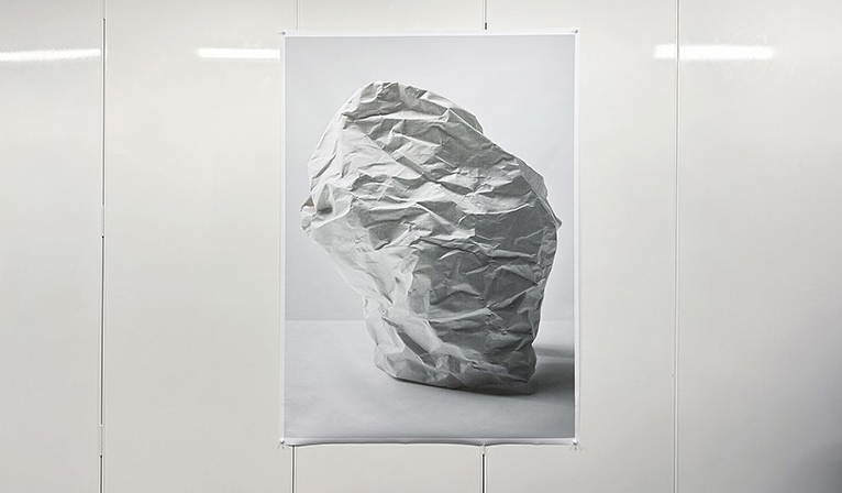 A photograph of a hanging sculpture shaped like crumpled paper.