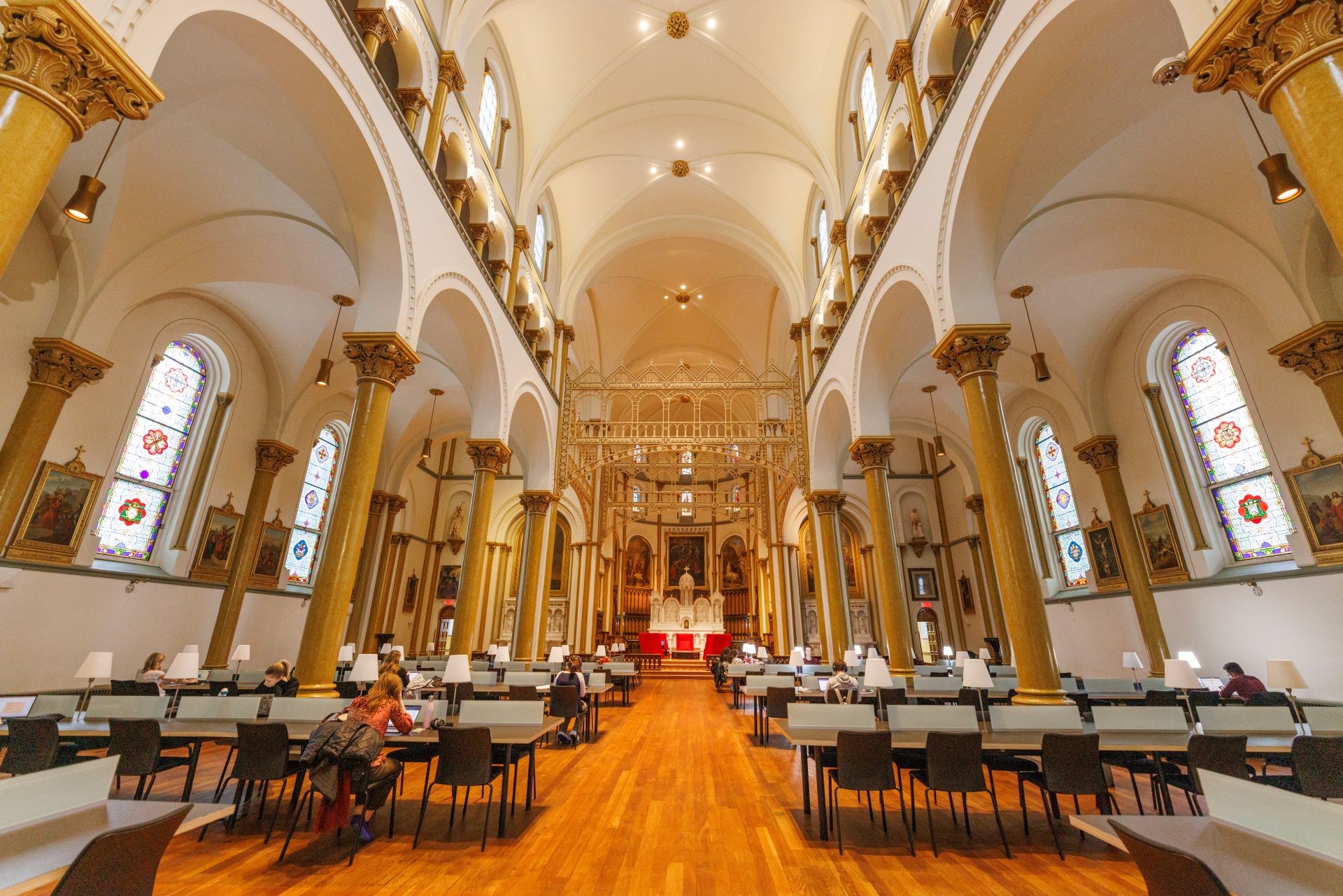 A converted chapel now serving as a reading room, with modern furniture set among traditional church architecture.