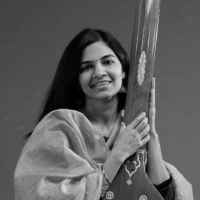 Portrait of a woman with long, dark hair holding an instrument