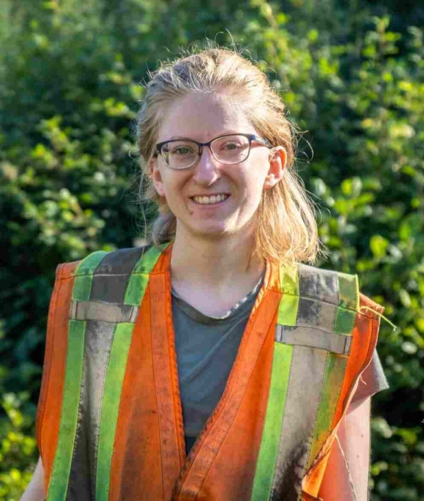 A photo of Valérie Bolduc, a blonde woman with glasses wearing a bright orange and yellow reflective vest