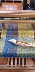 Image of a loom weaving cloth