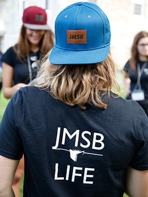 Student branded with JMSB LIFE shirt and cap