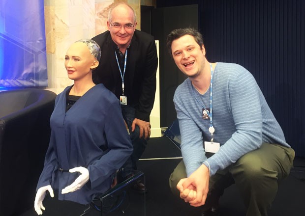À l’AI for Good Global Summit de Genève, Xavier-Henri Hervé (au centre) et Sydney Swaine-Simon posent en compagnie de Sophia, un robot humanoïde conçu chez Hanson Robotics. | Photo : District 3 À l’AI for Good Global Summit de Genève, Xavier-Henri Hervé (au centre) et Sydney Swaine-Simon posent en compagnie de Sophia, un robot humanoïde conçu chez Hanson Robotics. | Photo : District 3