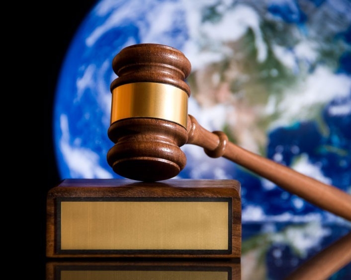 A gavel, with a background image of Planet Earth.