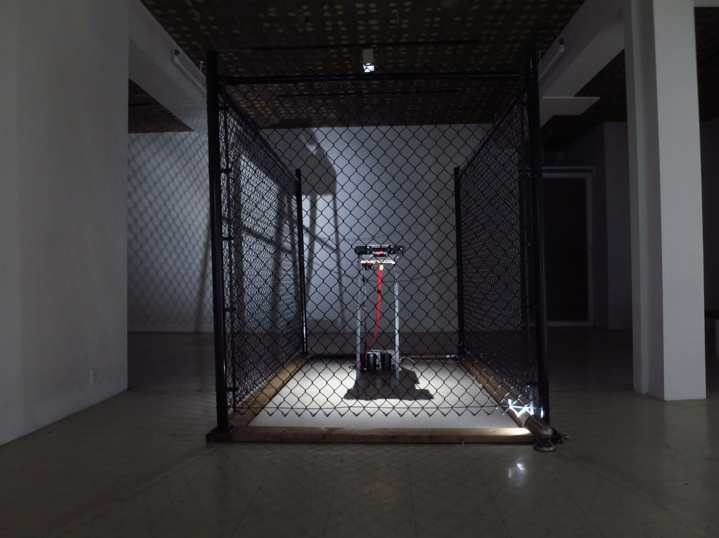Installation shot of a projector inside a cage