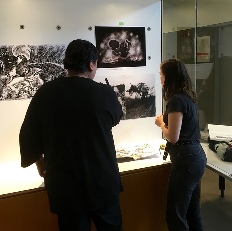 Co-curators Hanss Lujan Torres (left) and Renatta Critton-Papp (right) install the work of BFA candidate Jason Sikoak at Concordia's Art History Vitrine, one of four locations for the exhibition series Waterways: Asian Indigenous Relations in Contemporary Art.