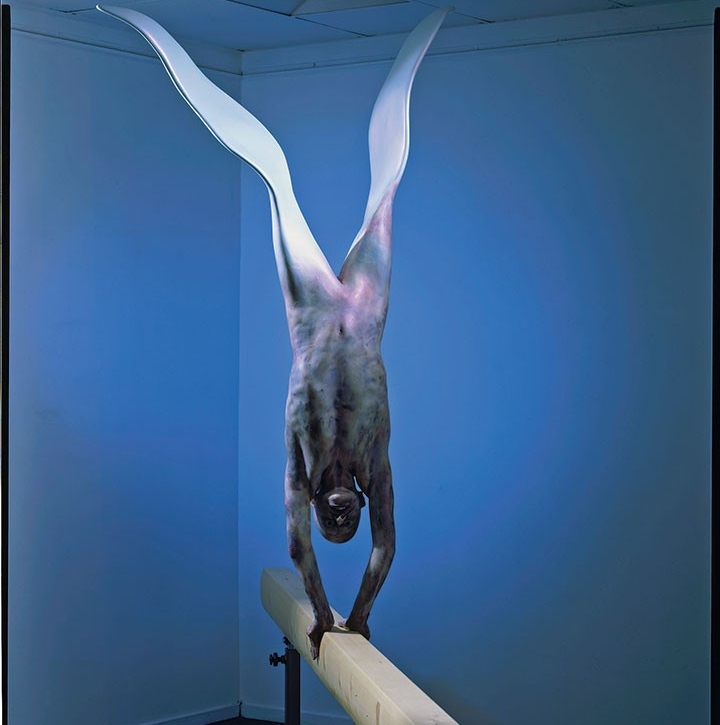 Drosophila, 1984, par Mark Prent. Figure ailée se tenant en appui sur les mains sur une poutre d’équilibre de près de cinq mètres.