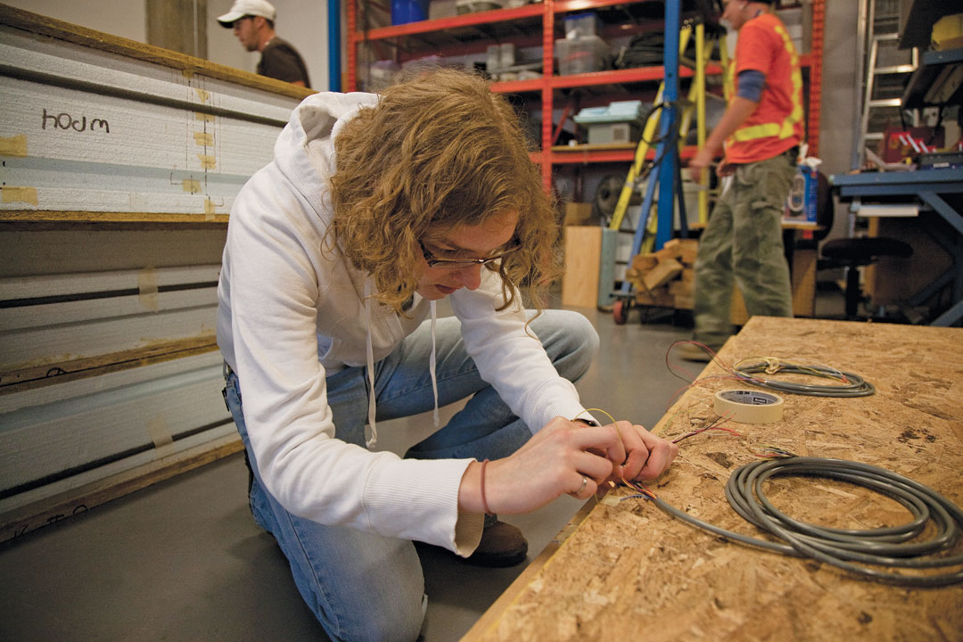 Master’s student Sara Wyss installs the sensor system she’s using to measure heat and moisture transfer.