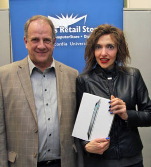 Prize winner Johanne De Cubellis (on right) accepts the iPad2 from Campus Retail Store Director Daniel Houde after her name was drawn at the May 3 event. | Photo courtesy of Campus Retail Stores.