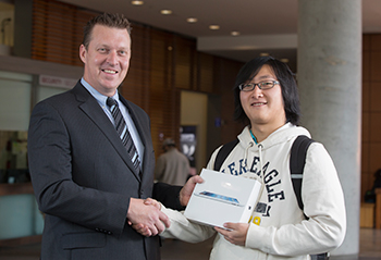 Emergency notification contest winner Peng Xu (right), receives his new iPad from Darren Dumoulin (left), senior advisor, emergency management. | Photo by Concordia University