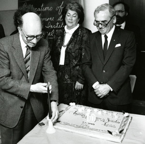 Cutting the cake at the tenth anniversary of the Simone de Beauvoir Institute is John O'Brien with Maïr Verthuy and Alan Gold looking on. | Photo courtesy of Records Management and Archives