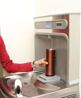 A student fills a reusable container at an Oasis water fountain. | Photo by Concordia University