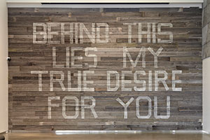 Mark Clintberg’s Behind this lies my true desire for you, 2012, Salvaged wood, latex paint, offset print posters, 670 cm x 944 cm. | Image courtesy of the Sobey Art Award
