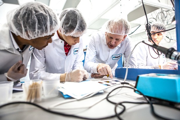 Rami Kandela and Ali Elawad examine solar cells with senior satellite designer Maarten Meerman.