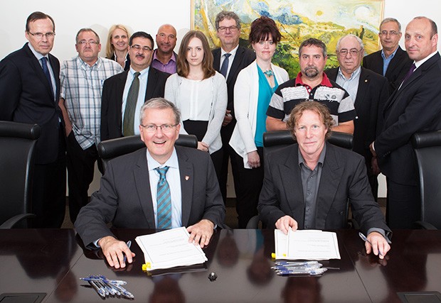 Concordia President Alan Shepard and Michael O'Hanley, principal delegate of United Steel Workers (USW), Local Section 9538, Loyola union sign the Métallos collective agreement.