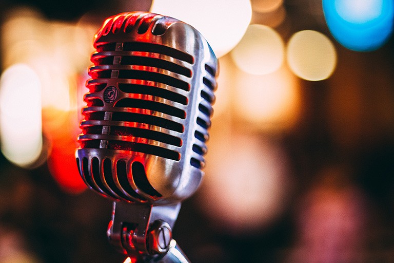 Image of a microphone with blurred, bokeh lights in the background.