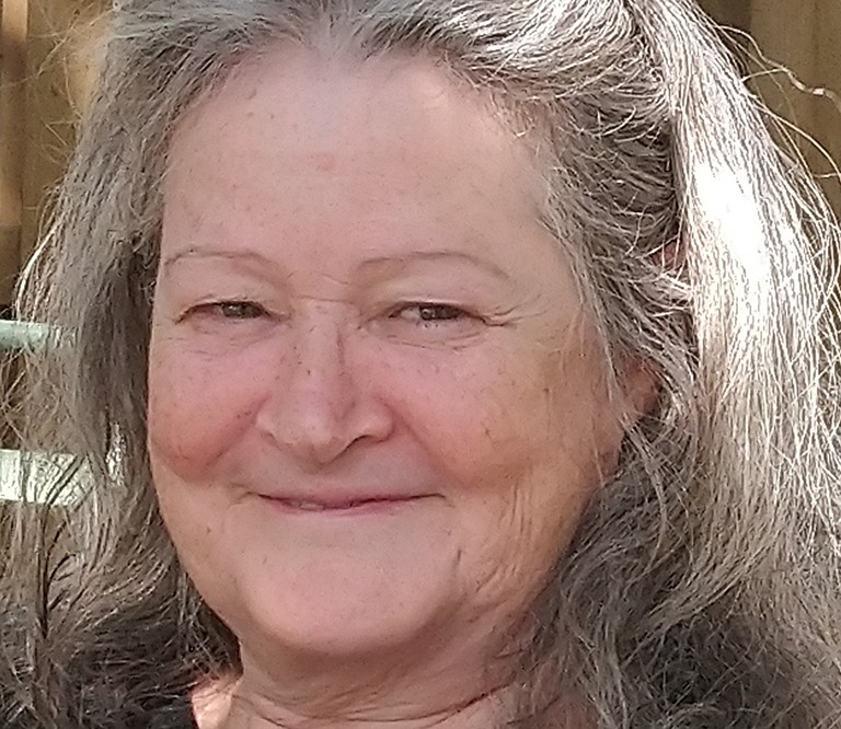 Smiling older woman with long blonde and gray hair.