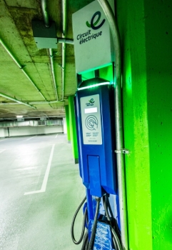 Electric Circuit charging station in underground parking with bright green walls