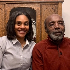 portrait of a smiling woman with short hair next to an older man with a beard, who is her father