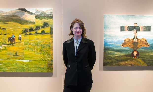Carol Ann Hunter Mclean standing between her paintings