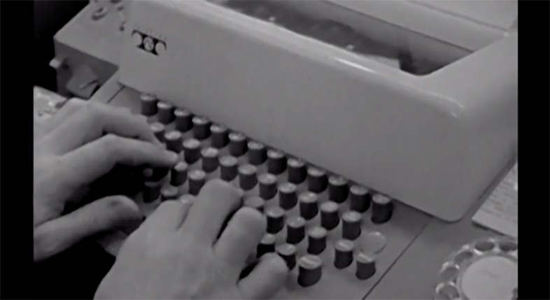 Image en noir et blanc de mains sur une machine à écrire