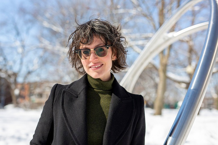 Young woman outside with sunglasses on a sunny winter day