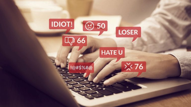 A graphic of a laptop and hateful words illustrating online toxicity