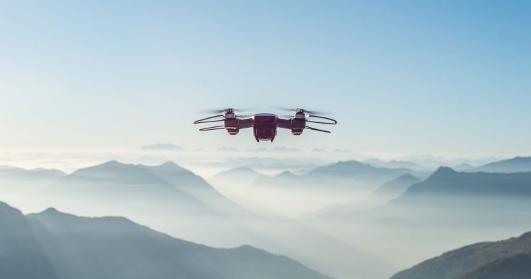 Image of a drone in the air with mountains in the distance