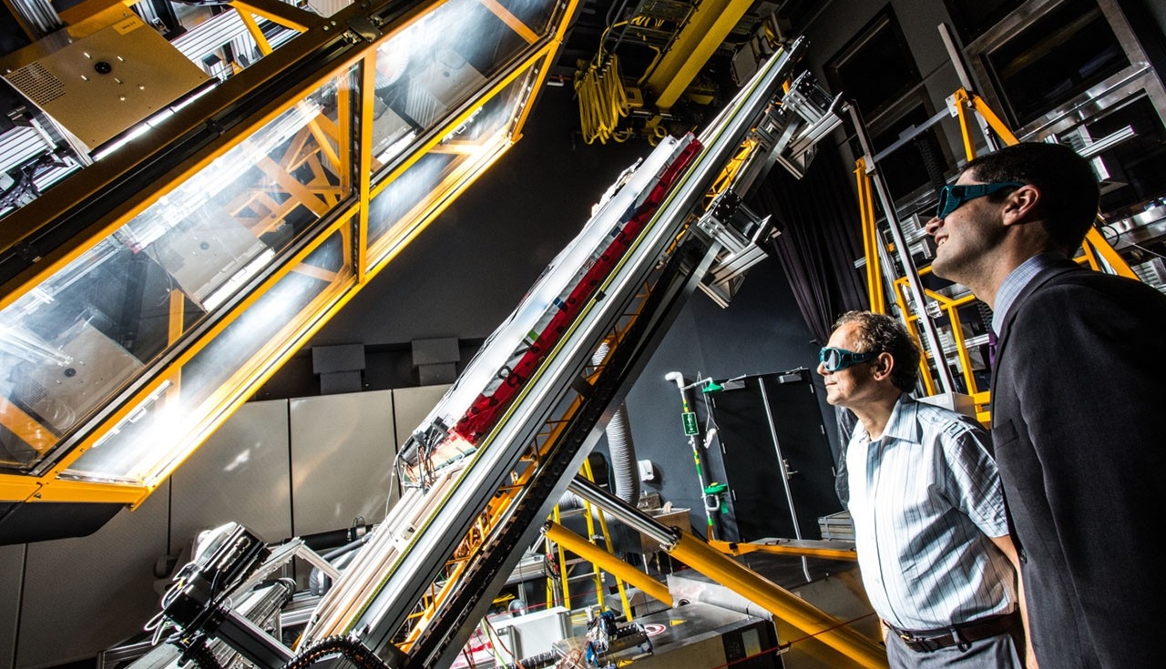 Deux scientifiques observent un équipement dans un laboratoire de haute technologie.