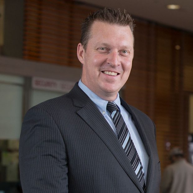 A man in a suit in a lobby area.