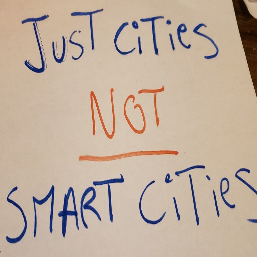 “Just cities not smart cities” written on a sign