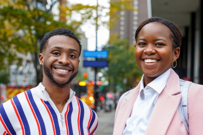 A young Black man and young Black woman, both smiling
