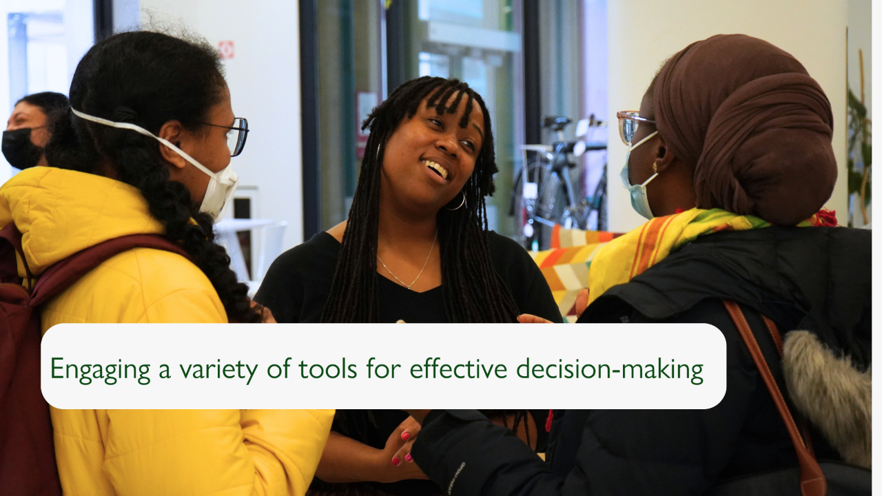 Slide with a photograph of three individuals in conversation, two with their back to the camera. The slide reads "Engaging a variety of tools for effective decision-making".