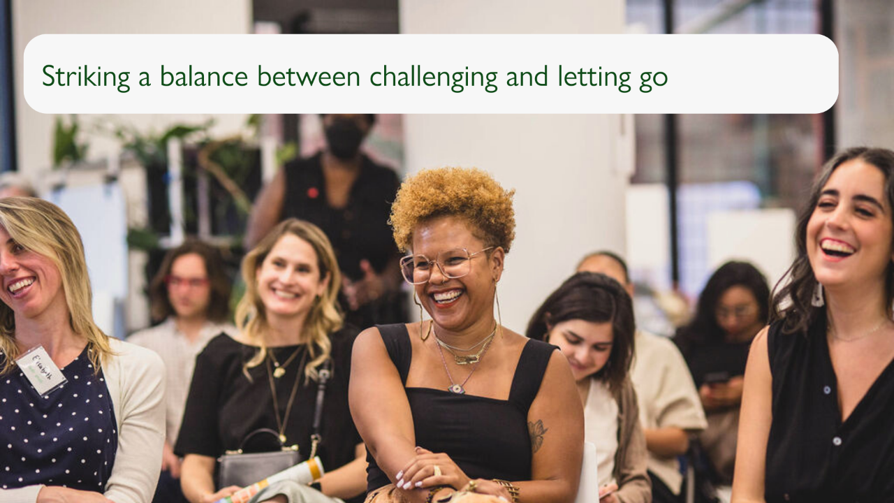 A slide with a photograph of an audience at an event, with three people in the front row in focus laughing. The slide reads "Striking a balance between challenging and letting go".