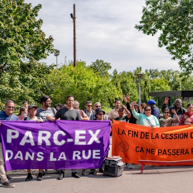 A photograph of protestors holding housing rights banners.