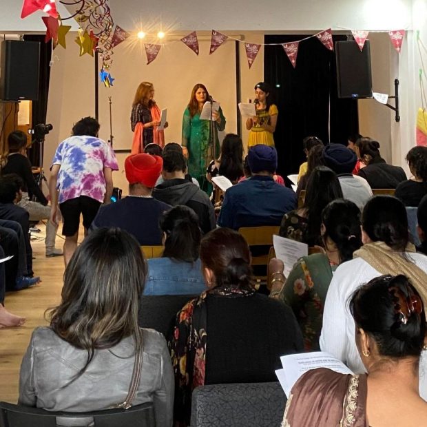 Photograph of a meeting at Brique par Brique's space with two people speaking on stage