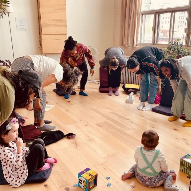A photograph of a parent-and-baby activity in a dance studio.