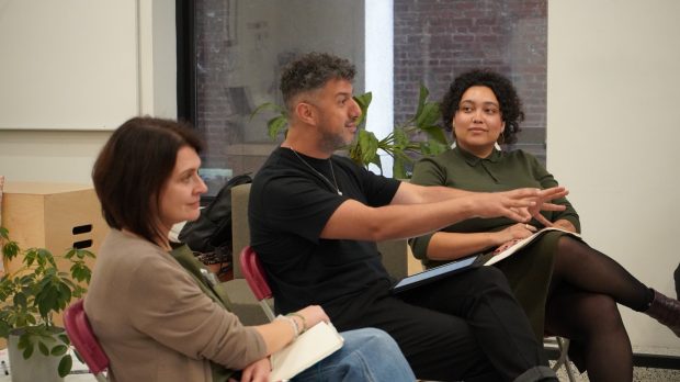 Images of shirtless men on the facade of the Stock Bar building with passersby walking along St. Catherine in the Gay Village. 