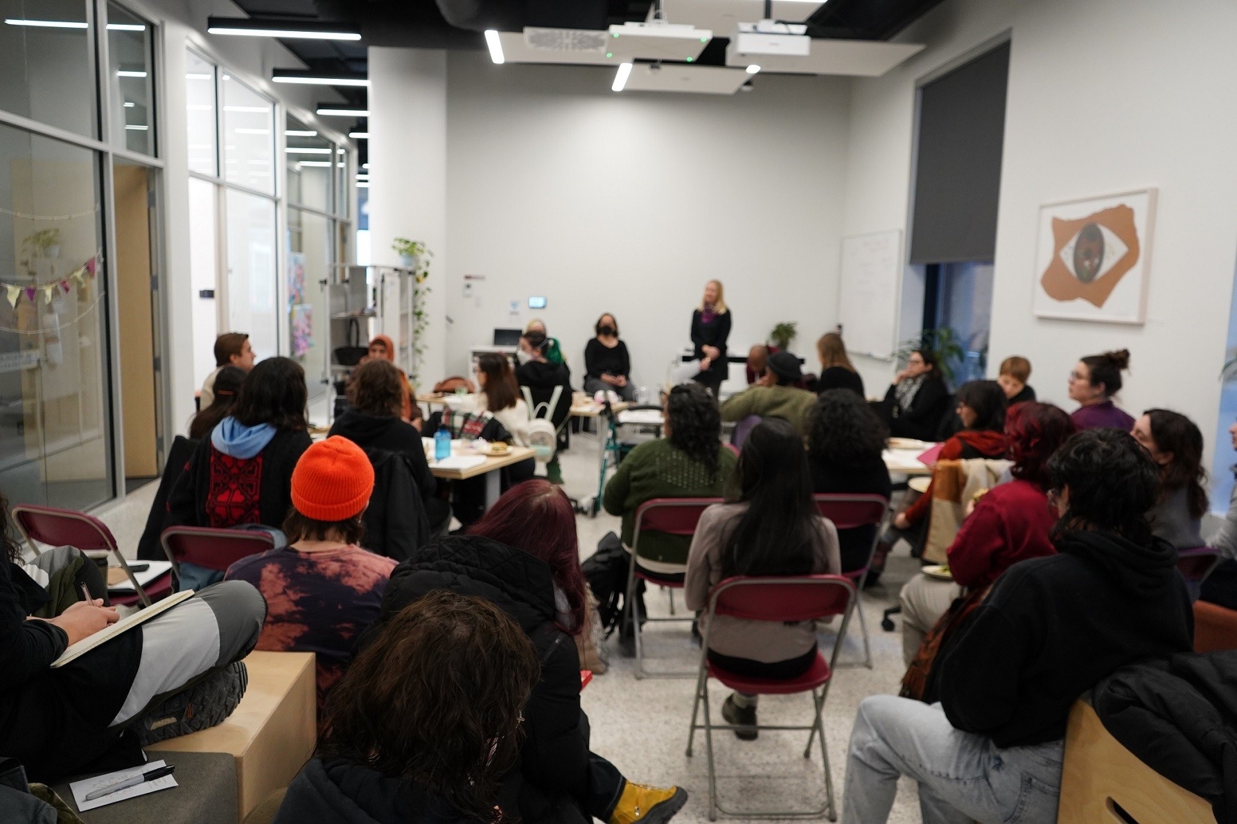 A crowd of seated people in the SHIFT open space during an event.