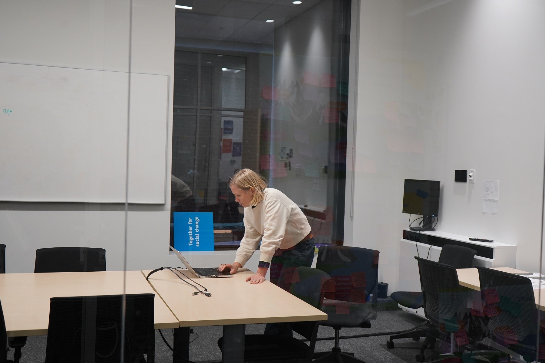 One person setting up their laptop in the conference room