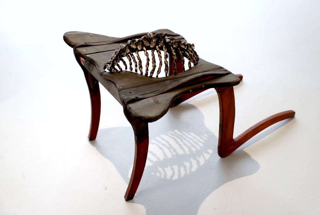 A sculpture of a chair with a stylized spine instead of a seat