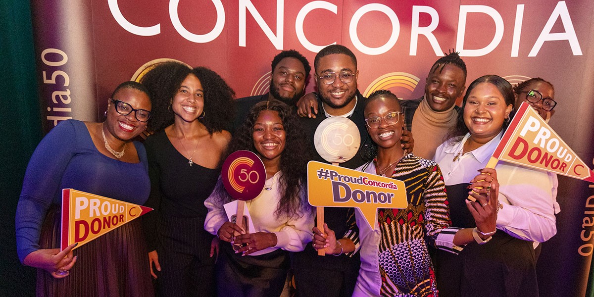A group of alumni, some holding signs that read "Proud donor."