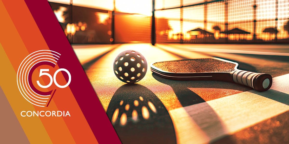 A pickleball court with a ball and racquet shining in the sun