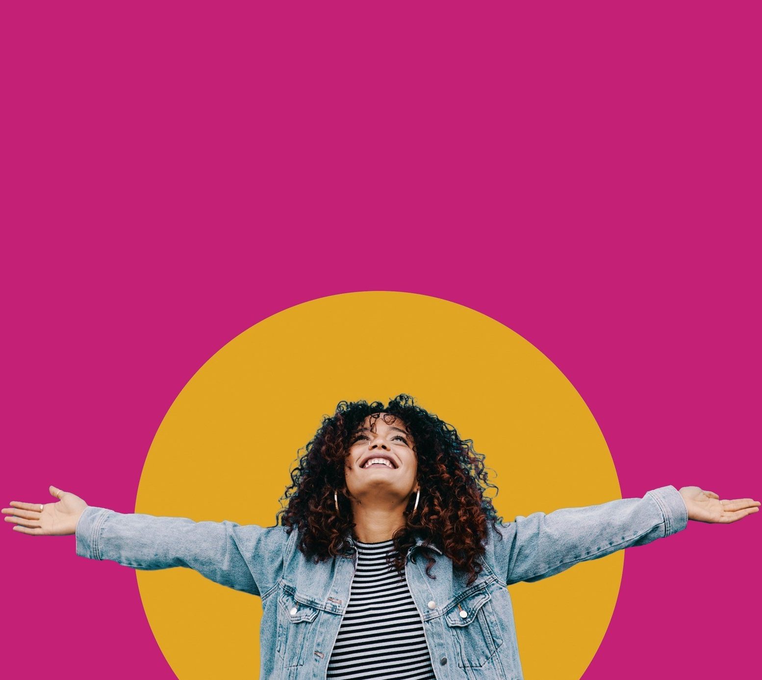 An exuberant woman with curly hair is smiling broadly with her eyes closed, arms wide open as if embracing the world. She's wearing a striped top underneath a denim jacket. The background is vibrant fuchsia with a large, mustard yellow circle positioned behind her, giving a lively and joyful composition to the image.
