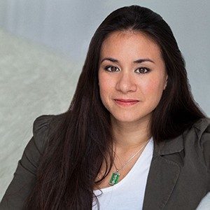 Portrait of a woman wearing a white T-shirt with a khaki blazer and jade pendant