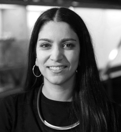 Black and white photo of a woman with long, black hair and wearing a black t-shirt.