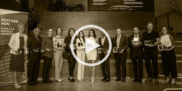 All the 2023 Alumni Recognition Awards recipients stand in a line, holding their award trophies