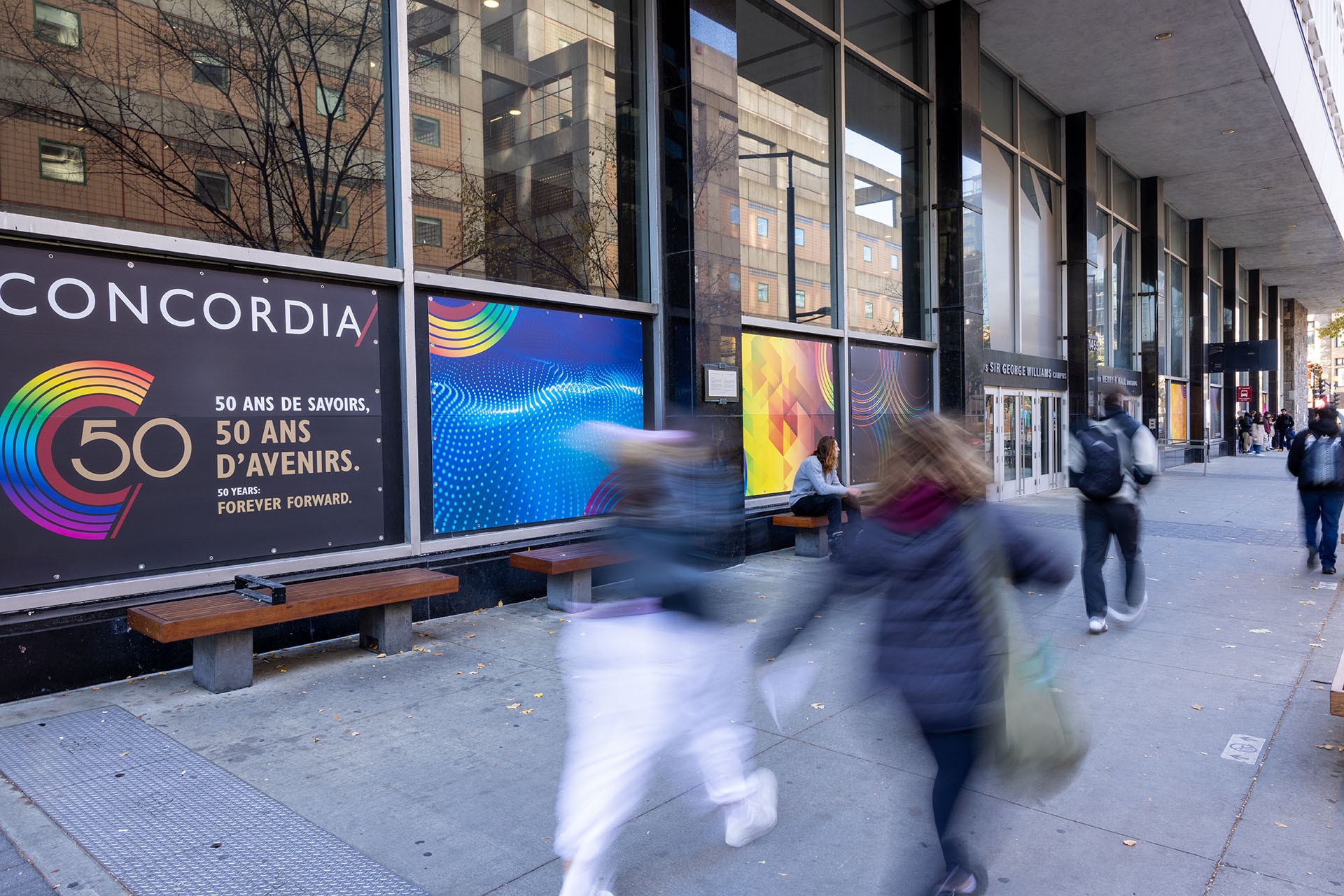 50th anniversary branding on the Hall building as people walk by.