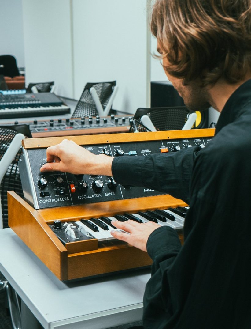 A student is working on a Moog synthesizer in the Department of Communications' synth space
