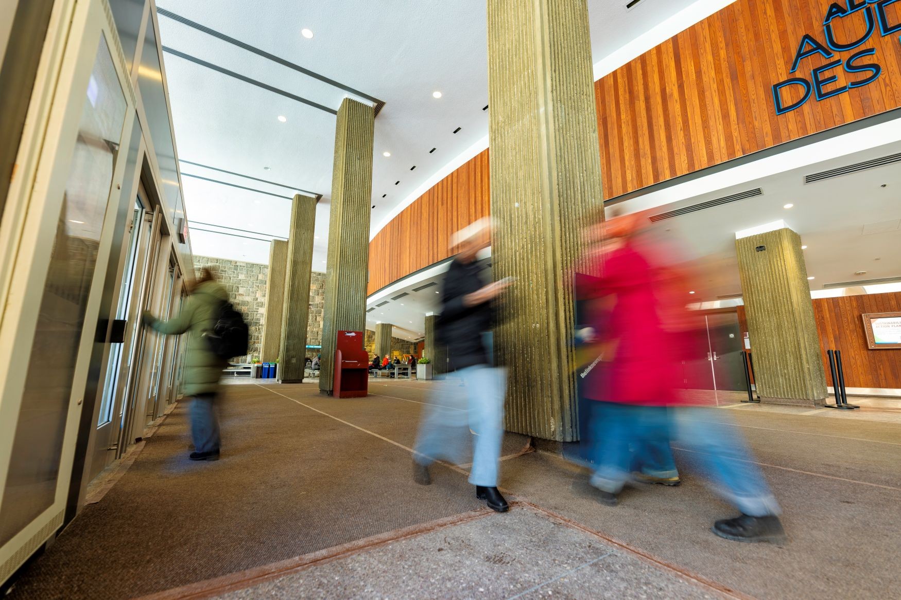 A photo of people walking through the Hall Building atrium